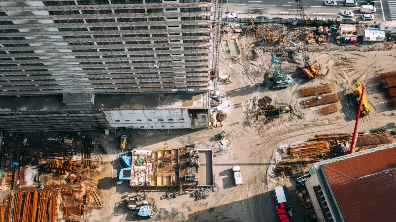 4k Time Lapse Flat View Construction And Development Of Modern Multi-storey Residential Houses. Development Multistorey Residential Building. Busy Urban Traffic. Various Machinery With Workers Are Engaged In Repairing Development On Construction Site. Cranes Are Working. Loading And Unloading Operations. Time Lapse, Timelapse, Time-lapse.